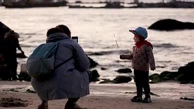 4k实拍傍晚海边亲子玩耍仙女棒动作视频的预览图